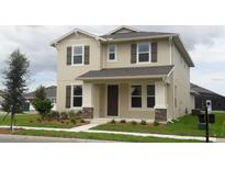 Two-story house with neutral siding, shutters, and landscaping at 15043 Pigeon Plum Ln, Winter Garden, FL 34787