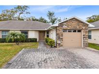 Inviting exterior with stone accents and a paved driveway at 2717 Shelby Ruth Pl, St Cloud, FL 34769