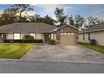 Charming single-story home featuring a stone accent garage and patterned brick driveway at 2717 Shelby Ruth Pl, St Cloud, FL 34769