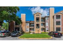 Tan three-story building with balconies and lush landscaping at 4200 Thornbriar Ln # 305, Orlando, FL 32822