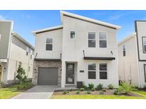 Modern two-story house with gray garage door and stone accents at 4370 Rhyme St, Kissimmee, FL 34746