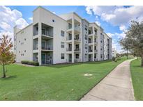 Modern apartment building with landscaped grounds and walking path at 4741 Clock Tower Dr # 306, Kissimmee, FL 34746