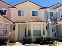 Two story townhome with light colored siding and a red tile roof at 1240 S Beach Cir, Kissimmee, FL 34746