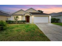 Inviting one-story home with a well-manicured lawn and attached garage at 15434 Markham Dr, Clermont, FL 34714
