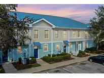 Front view of charming townhouses with blue roofs and light-colored siding at 2015 Grand Oak Dr, Kissimmee, FL 34744