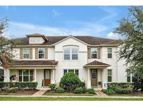 Two-story townhome with neutral siding, brown accents, and landscaping at 2603 Amati Dr, Kissimmee, FL 34741