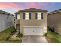 Two-story house with a white garage door and blue shutters at 113 Eagleview Loop, Davenport, FL 33837
