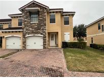 Two-story townhome with two-car garage and brick paved driveway at 1427 Pacific Rd, Kissimmee, FL 34759