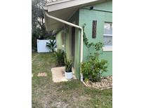 Green house exterior with walkway, landscaping, and white fence at 1808 S Mulberry Ave, Sanford, FL 32771