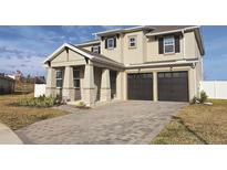 Two-story home with a two-car garage and paver driveway at 2016 Keystone Pass Blvd, Minneola, FL 34715