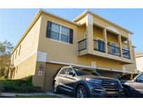 Tan two-story house with a two-car garage and a balcony at 2220 Betsy Ross Ln # C, St Cloud, FL 34769