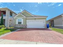 Charming single-story home with a brick driveway, two-car garage, and well-maintained lawn at 2820 Avian Loop, Kissimmee, FL 34741