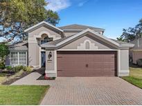 Two-story house with brown garage door and landscaped yard at 336 Del Sol Ave, Davenport, FL 33837