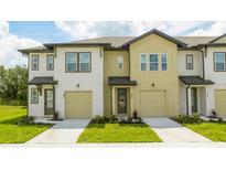 Two-story townhome with neutral siding, attached garage, and landscaping at 607 Longboat Dr, Davenport, FL 33896