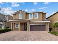 Two-story house with brown exterior, a three-car garage, and a paved driveway at 7617 Wilmington Loop, Kissimmee, FL 34747