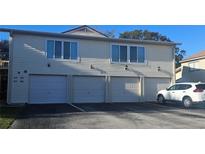 Exterior view of a light yellow multi-unit building with attached garages at 1022 Spring Meadow Dr # 1022, Kissimmee, FL 34741