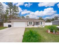 Single-story home with a white garage door and landscaped yard at 3 Pecan Drive Loop, Ocala, FL 34472