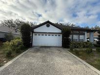 Charming single-story home featuring a two-car garage, well-kept landscaping, and a cozy front porch at 143 Glasgow Ct, Davenport, FL 33897