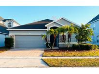 One-story home with gray siding, herringbone driveway, and palm trees at 2304 Cedar Garden Dr, Orlando, FL 32824