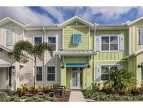 Inviting two-story townhome with colorful shutters, front yard landscaping, and a welcoming entryway at 2929 Caribbean Soul Dr, Kissimmee, FL 34747