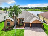 Single-Gathering home with a two-car garage and a lake view at 754 Golf Course Pkwy, Davenport, FL 33837