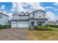 Two-story house with three-car garage and landscaped front yard at 8024 Leaf Grove Cir, Orlando, FL 32836