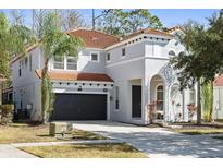 Two-story house with gray exterior, tile roof, and a two-car garage at 901 Marcello Blvd, Kissimmee, FL 34746