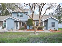 Charming blue home featuring a well-maintained lawn and inviting front entryway at 118 Hidden Arbor Ct, Sanford, FL 32773