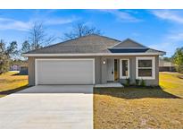 Newly constructed one-story home with attached garage and landscaped yard at 13404 Sw 60Th Court Rd, Ocala, FL 34473