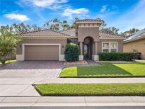 Single-story home with a two-car garage and landscaped lawn at 1632 Nina Dr, Davenport, FL 33837