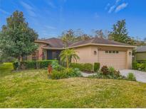 Single-story home with landscaped yard and attached garage at 203 Los Gatos Pl, Poinciana, FL 34759