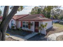 Cozy single-story home featuring mature trees, red shutters, and well-maintained landscaping at 46 W Marbrisa Way, Kissimmee, FL 34743