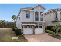 Beautiful two-story home with a stone-accented facade, a balcony, and a two-car garage at 733 Desert Mountain Ct, Reunion, FL 34747