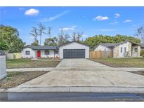 Newly renovated home with a red door and a spacious driveway at 8607 Tarragon Dr, Orlando, FL 32825