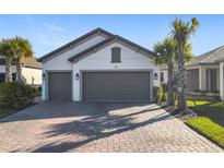 Two-car garage, light gray exterior, and a paved driveway at 1062 Umbria Dr, Kissimmee, FL 34759