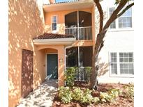 Inviting condo exterior featuring a teal door and screened balcony at 12414 Baleria Cv # 108, Orlando, FL 32837