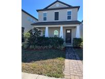 Two-story house with gray siding, dark brown door, and landscaped front yard at 1478 Garden Arbor Ln, Orlando, FL 32824