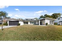 White brick house with a black garage door and landscaped lawn at 2061 Geronimo Trl, Maitland, FL 32751