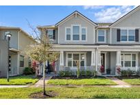 Charming two-story townhome featuring a covered front porch and well-maintained landscaping at 2276 Centerra Loop, Kissimmee, FL 34741