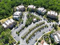 A captivating aerial view of condo community surrounded by lush greenery and ample parking at 7658 Whisper Way # 202, Reunion, FL 34747