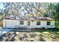 Charming ranch home with white brick exterior and a spacious lawn at 1080 Springbank Ave, Orange City, FL 32763