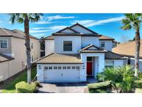 Two-story home with tile roof, white exterior, and a two-car garage at 1320 Moss Creek Ln, Davenport, FL 33836