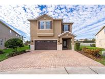 Two-story house with brown brick driveway and landscaping at 250 Pendant Ct, Kissimmee, FL 34747