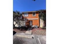 Front view of two-story townhome with orange exterior and small front yard at 28 Silver Falls Cir, Kissimmee, FL 34743