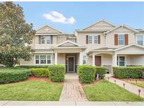 Two-story townhome with a landscaped front yard and brick walkway at 6530 Stoller Ave, Windermere, FL 34786