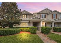 Two-story townhome with a landscaped front yard and brick walkway at 6530 Stoller Ave, Windermere, FL 34786