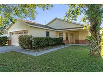 One-story house with attached garage, manicured lawn, and well-maintained landscaping at 8077 Roaring Creek Ct, Kissimmee, FL 34747