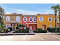 Three-unit townhome building with parking, featuring colorful exteriors and landscaping at 8552 Crystal Cove Loop, Kissimmee, FL 34747