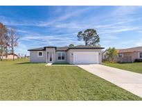 New single-story home with attached garage and grassy yard at 15321 Sw 43Rd Avenue Rd, Ocala, FL 34473