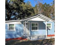 Newly renovated light blue house with a covered porch, fresh landscaping, and a white door at 217 W Chelsea St, Deland, FL 32720
